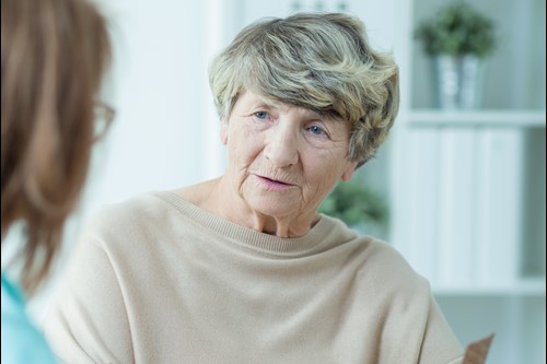 An older person and a nurse discuss medication